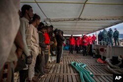 Migrants gather on the deck of the Spanish NGO Proactiva Open Arms rescue vessel after being rescued in the central Mediterranean sea Dec. 21, 2018, before disembarking in the port of Crinavis in Spain, Dec. 28, 2018.