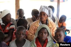 FILE - Mothers and children, refugees from from Democratic Republic of Congo, wait to be registered by UNHCR personnel, in Ntoroko, Uganda, Feb. 17, 2018.