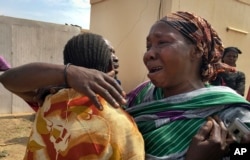 FILE - Relatives of six aid workers who were ambushed and killed grieve as they wait to collect and bury the bodies of their loved ones, outside the morgue in Juba, South Sudan, March 27, 2017.