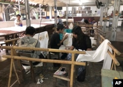 Para pekerja membuat batik di pabrik batik di Yogyakarta, 30 Juli 2019. (Foto: AP)