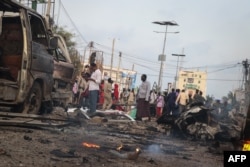 FILE - People gather at the scene of twin car bombs that exploded within moments of each other in the Somali capital Mogadishu, Nov. 9, 2018, near a popular Sahafi hotel in the Somali capital Mogadishu.