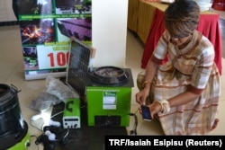 Rose Twine, director of Eco Group Limited, demonstrates a volcanic rock stove in Kampala, Uganda, April 20, 2017.