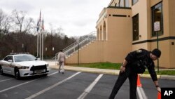 A Loudoun County (Va.) sheriff's deputy moves a traffic cone at the All Dulles Area Muslim Society Center in Sterling, Va., where security guards resigned because they felt they could no longer protect the mosque amid anti-Muslim sentiment, Dec. 18, 2015.