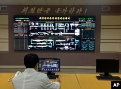 An employee monitors production from the control room of the Ryugyong Kimchi Factory in Pyongyang, North Korea, Dec. 20, 2017.