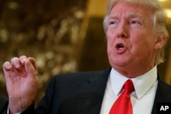 President-elect Donald Trump speaks with reporters in the lobby of Trump Tower in New York, Jan. 13, 2017.