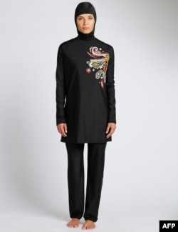 In a recent undated handout picture released by British retailer Marks and Spencer on April 8, 2016 a model poses wearing one of Marks and Spencer's full-body bathing suit or burkini suit.