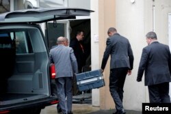 Men unload a case from a diplomatic car from the Ethiopian Embassy outside the headquarters of France's BEA air accident investigation agency in Le Bourget, France, March 14, 2019. The black boxes from the crashed Ethiopian Airlines Boeing 737 Max 8 arrived in France on Thursday.