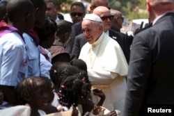 FILE - Pope Francis greets internally displaced people sheltering on the grounds of the Saint Sauveur church, during his visit in the capital Bangui, Central African Republic, Nov. 29, 2015.
