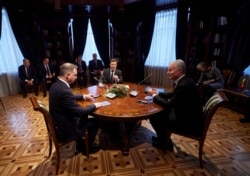 Ukrainian President Volodymyr Zelenskiy, center, Poland's President Andrzej Duda, left, and Lithuania's President Gitanas Nauseda are seen during their meeting at the presidential residence in Ukraine's, Ivano-Frankivsk region, Dec. 20, 2021. (Ukrainian P