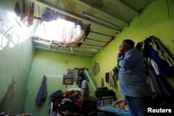 FILE - People check the damage after debris from ballistic missiles fired by Yemen's Houthi militia fell onto a house in Riyadh, Saudi Arabia.
