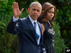 President Barack Obama and first lady Michelle Obama walk across the South Lawn of the White House in Washington, July 12, 2016, to board Marine One for a short trip to Andrews Air Force Base, Maryland, before traveling to Dallas.