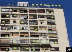 Yellow vests hang on the rooftop and at windows of an apartment building, Dec. 7, 2018, in Marseille, southern France.