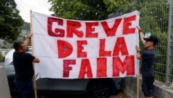 FILE - Protesters hold a banner which reads "Hunger strike" to demonstrate against France's restrictions to fight the coronavirus pandemic, near the Abbaye Saint-Pons in Nice, France, September 15, 2021.