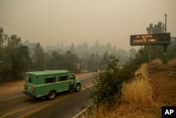 A fire transport drives along Highway 140, one of the entrances to Yosemite National Park, in Mariposa, Calif., July 16, 2018.