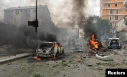 FILE - Vehicles burn at the scene of an explosion in Mogadishu, Somalia, July 30, 2017.