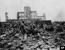FILE - A man looks over the expanse of ruins left the explosion of the atomic bomb in Hiroshima, Japan, August 6, 1945.