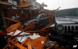 A storm chaser climbs into his vehicle during the eye of Hurricane Michael to retrieve equipment after a hotel canopy collapsed in Panama City Beach, Florida, Oct. 10, 2018.