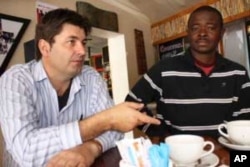 Etienne Barkhuysen (left), a South African businessman who cooperated with the Nigerians to "clean up" historic Parliament Street, makes a point during an interview with VOA