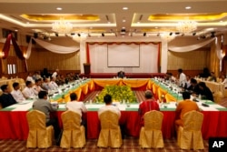 FILE - A representative of an armed ethnic group, right, speaks during the second day session of a ceasefire monitoring meeting while Myanmar's de facto leader Aung San Suu Kyi, top center, April 27, 2016, in Naypyitaw.