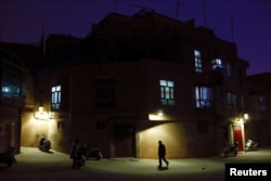 A man walks along a street at night in the old town of Kashgar, Xinjiang Uighur Autonomous Region, China, March 23, 2017. Thousands of "convenience police stations" have been built across Xinjiang. They are typically just hundreds of meters apart in what party boss Chen Quanguo calls a "grid-style social management system."