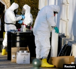 Officials dressed in protective suits prepare to enter the closed Russell Senate Office Building on Capitol Hill, to retreive mail that could be contaminated, Feb. 4, 2004.