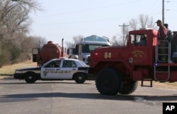 Firefighters move past a road block near Hutchinson, Kansas, March 7, 2017.