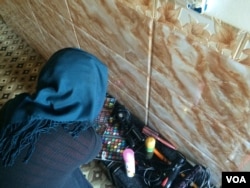 Safaa examines some of the beauty products she hid from IS militants before they came back to confiscate her possessions again while they were in control of her area in Mosul, Iraq, Feb. 7, 2017. (H. Murdock/VOA)