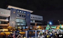 Demonstrators protest against Brazil's former president Luiz Inacio Lula da Silva outside the Federal Police Department where he was taken in Curitiba, Brazil, late Saturday, April 7, 2018.