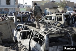 A Houthi fighter walks on a vehicle damaged by an air strike at a residential area near Sanaa Airport March 26, 2015. REUTERS/Khaled Abdullah