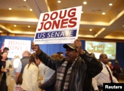 A supporter holds a sign during Democratic U.S. Senate candidate Doug Jones' election night party in Birmingham, Alabama, Dec. 12, 2017.