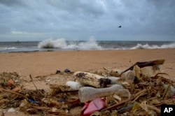 FILE - A plastic bottle lies among other debris washed ashore on an Indian Ocean beach in Uswetakeiyawa, north of Colombo, Sri Lanka, Aug. 13, 2015.