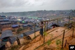 FILE - A Rohingya Muslim man, who crossed over from Myanmar into Bangladesh, builds a shelter for his family in Taiy Khali refugee camp, Bangladesh, Sept. 20, 2017.