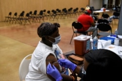 A person receives a vaccine for COVID-19 at Acres Home Multi-Service Center in Houston, Texas, October 13, 2021.