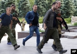 UKRAINE – Aleksandr Borodai, Russian citizen and "Prime Minister" of the self proclaimed "Donetsk People's Republic", center, walks accompanied by pro-Russian fighters in Donetsk, eastern Ukraine, July 20, 2014