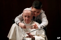 A boy takes a selfie with Pope Francis, during a visit to the parish of Santa Maria Josefa del Cuore di Gesu', in Rome, Feb. 19, 2017.