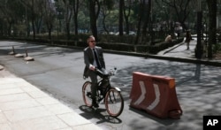 A man rides his bicycle along Reforma Avenue in Mexico City, April 6, 2016. Authorities barred millions of vehicles due to smog levels.