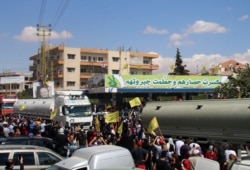 Orang-orang mengibarkan bendera gerakan Syiah Lebanon Hizbullah, saat menyambut kedatangan tanker yang membawa bahan bakar Iran dari Suriah, di kota Baalbeck, lembah Bekaa Lebanon, 16 September 2021.