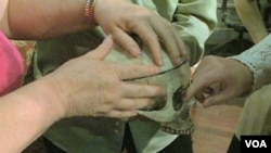 Visually-impaired theatergoers touch the skull, a prop in Everyman Theatre's production of "You Can’t Take It With You."