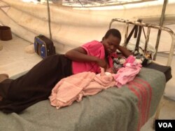 A mother lies with her child in a makeshift clinic after delivering the baby at the Chingwizi transit camp, February 2016. (S. Mohfu/VOA)