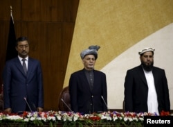 Afghanistan's President Ashraf Ghani, center, stands at attention for the national anthem during his visit at the joint National assembly gathering in Kabul, Afghanistan, April 25, 2016.