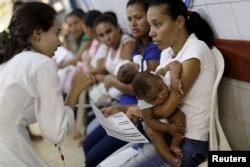 FILE - Mothers with their children, who have microcephaly, await medical care at the Hospital Oswaldo Cruz, in Recife, Brazil, Jan. 26, 2016.