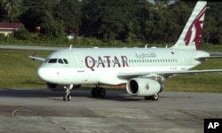 FILE - A Qatar Airways plane sits on the tarmac at Yangon International Airport in Yangon, Myanmar, Oct. 4, 2012.