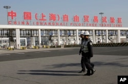 FILE - Security guards patrol the main gate of the China (Shanghai) Pilot Free Trade Zone at the Pudong International Airport in Shanghai, China.