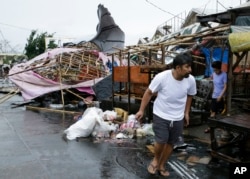 A resident walks past damaged stalls at a public market as Typhoon Mangkhut barreled across Tuguegarao city in Cagayan province, northeastern Philippines, Sept. 15, 2018.
