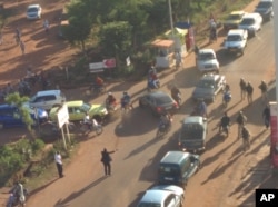 FILE - In this image made available by Malikahere.com security personnel, right, arrive close to the scene of an attack on a hotel in Bamako, Mali, Nov. 20, 2015.