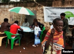 FILE - A Kenyan woman leaves a voter registration center on the last day of the exercise in Nairobi.