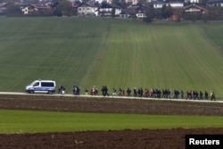 Imigran dikawal oleh polisi Jerman ke pusat pendaftaran, setelah melintasi perbatasan Austria-Jerman di Wegscheid dekat Passau, Jerman, 20 Oktober 2015. (REUTERS/Michael Dalder)