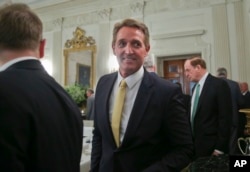 FILE - Sen. Jeff Flake, R-Ariz., center, walks to his seat as he attends a luncheon with other GOP senators and President Donald Trump, July 19, 2017, in the State Dining Room of the White House in Washington.