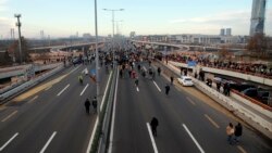 Protesters stand on the highway during a protest in Belgrade, Serbia, Nov. 27, 2021. Anti-government demonstrators blocked roads and bridges in protest of new laws they say favor interests of foreign investors devastating the environment.