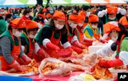 South Koreans and tourists make kimchi to donate to needy neighbors during the Seoul kimchi festival in Seoul, South Korea, Nov. 6, 2015.